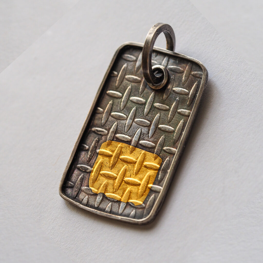 Silver oxidized dog tag pendant with a 24k gold badge