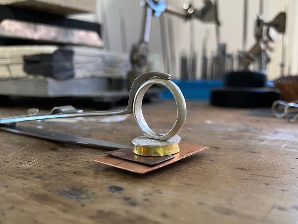 Gold and Silver ring on jewelry workbench being created.
