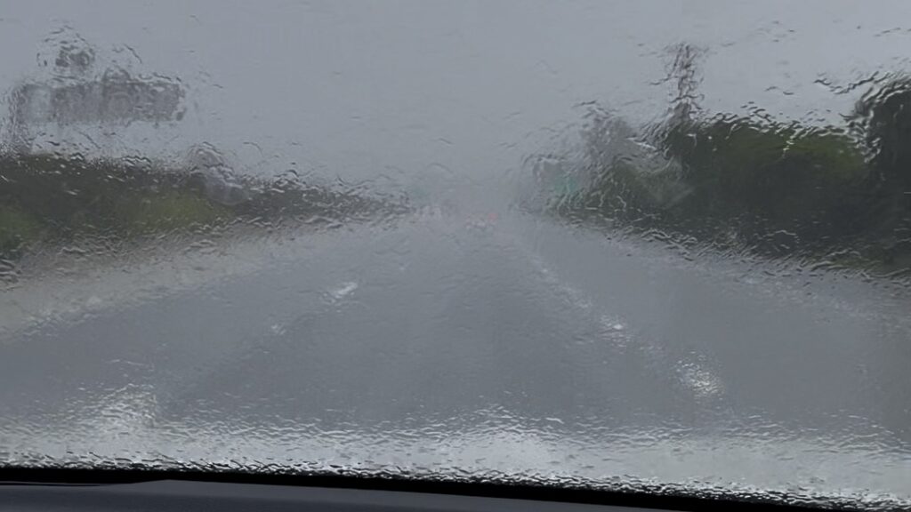 View through car windshield of storm on California coastal freeway