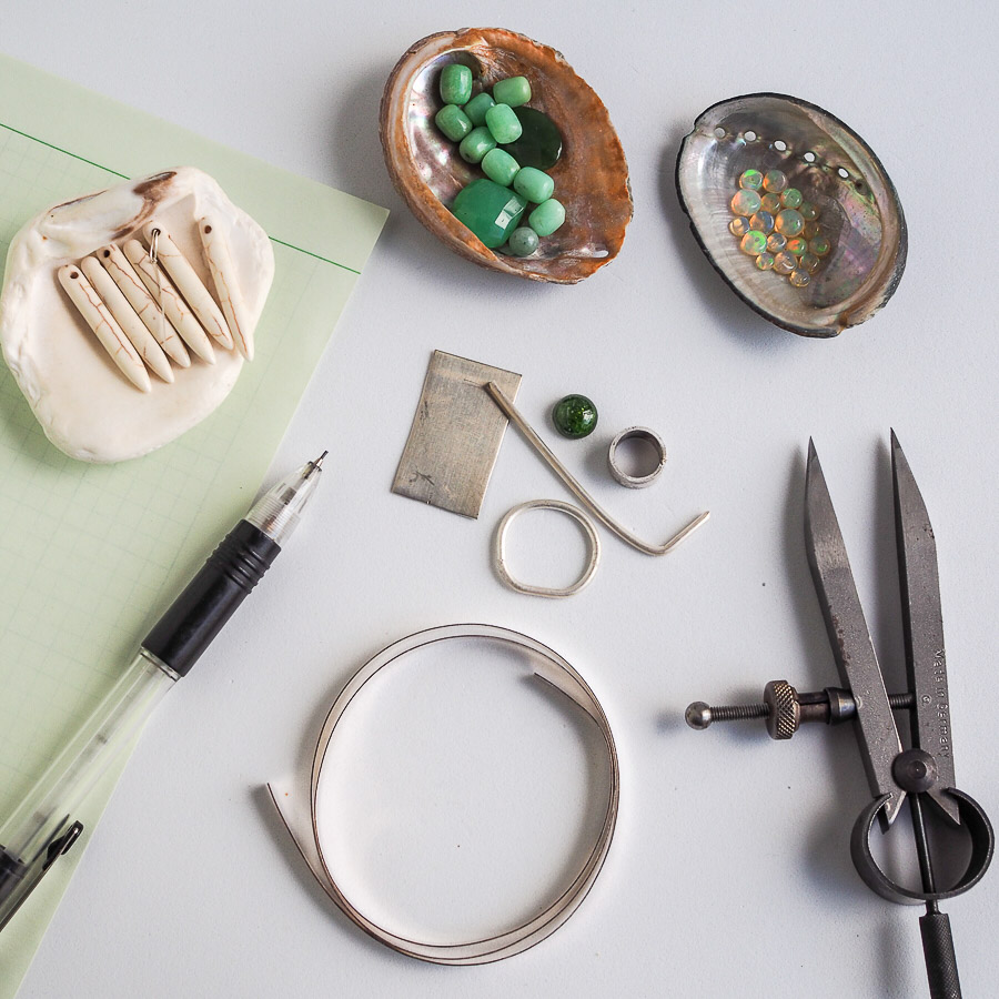 Gathering of materials for building earrings with chrysoprase and howlite beads.